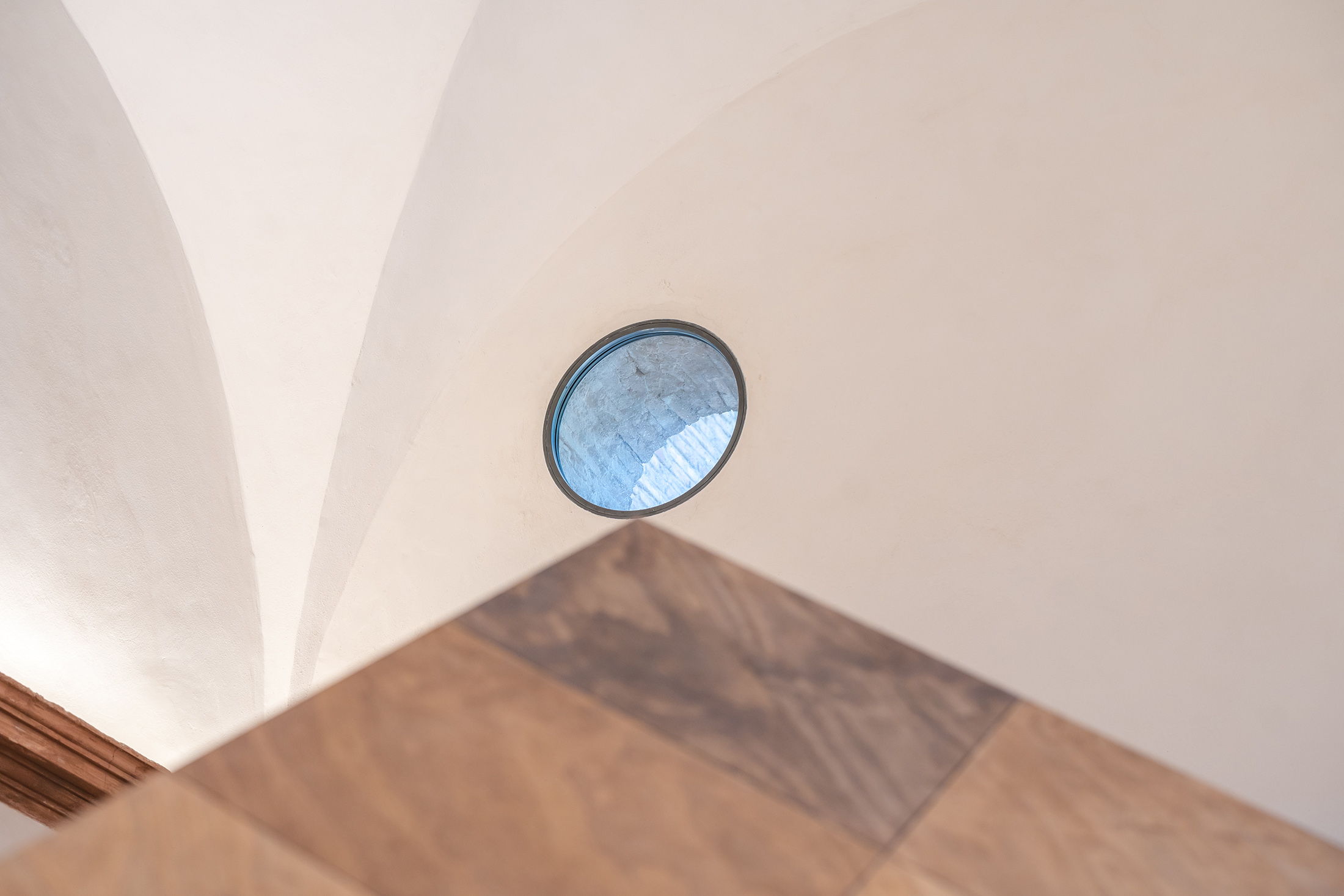 Entrada de luz natural a través de un óculo circular en la bóveda blanca